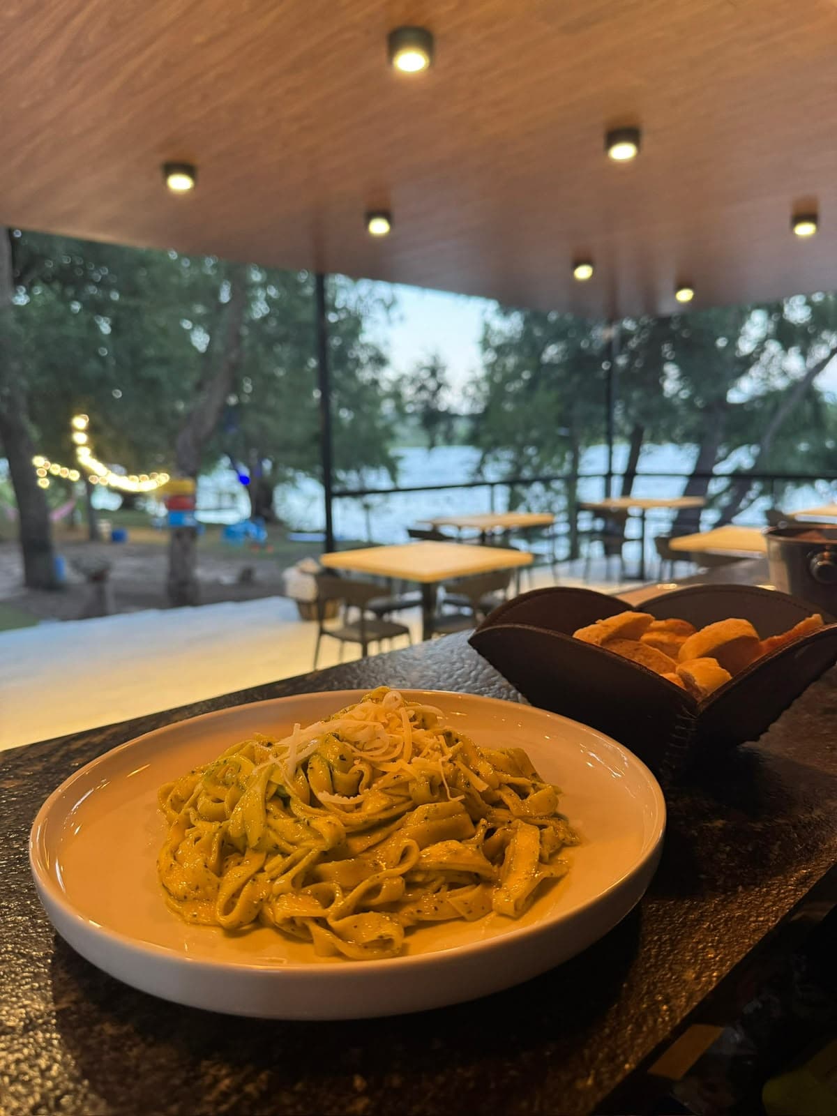 Tagliatelle alla carbonara with shaved parmesan, bread basket on the side
