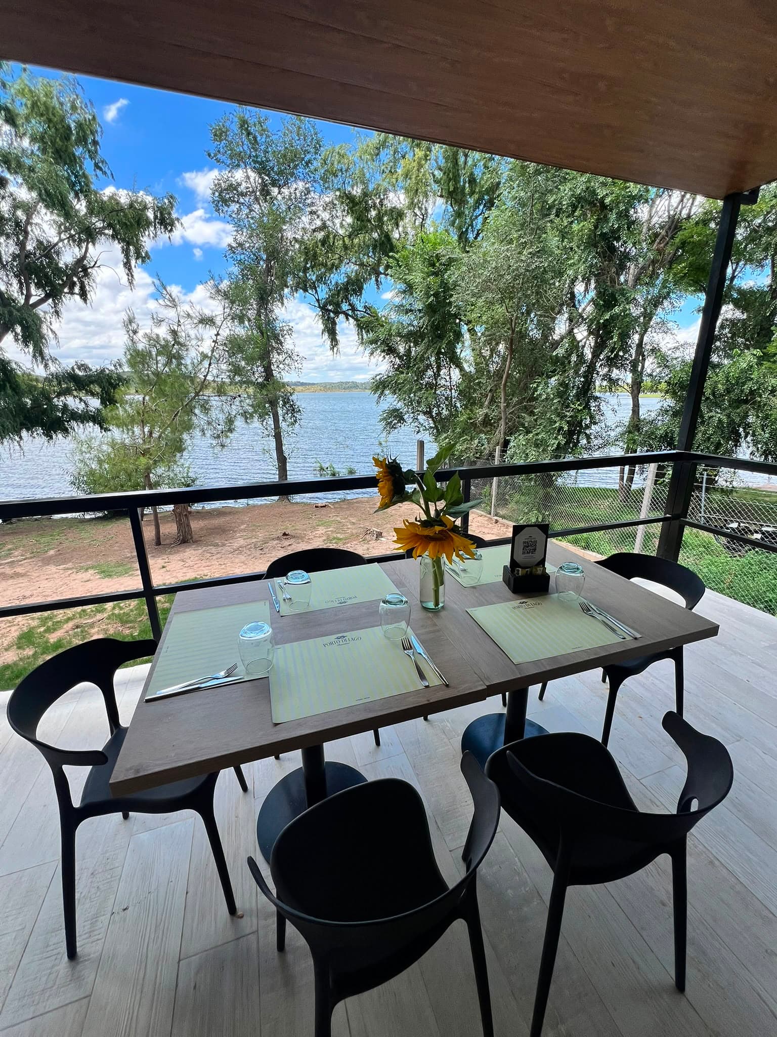 Table set for two on the deck, overlooking the lake through the trees