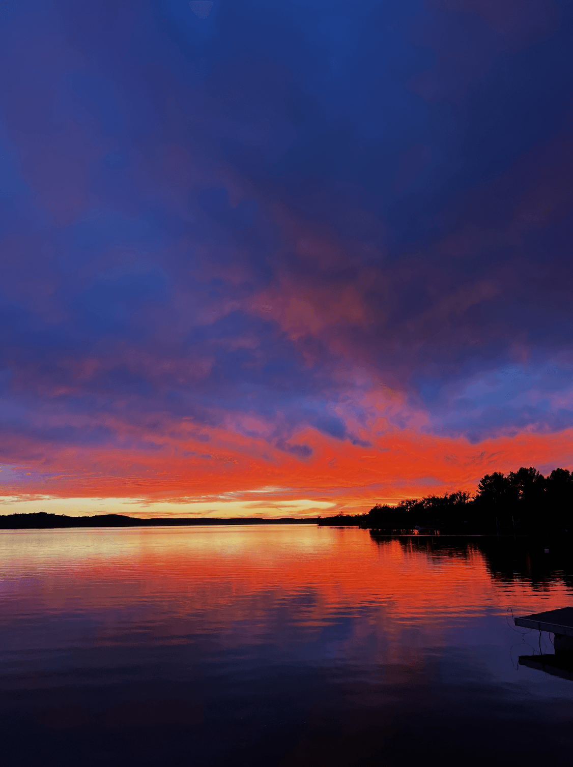 Fiery sunset over Embalse La Florida, reflected in the still lake